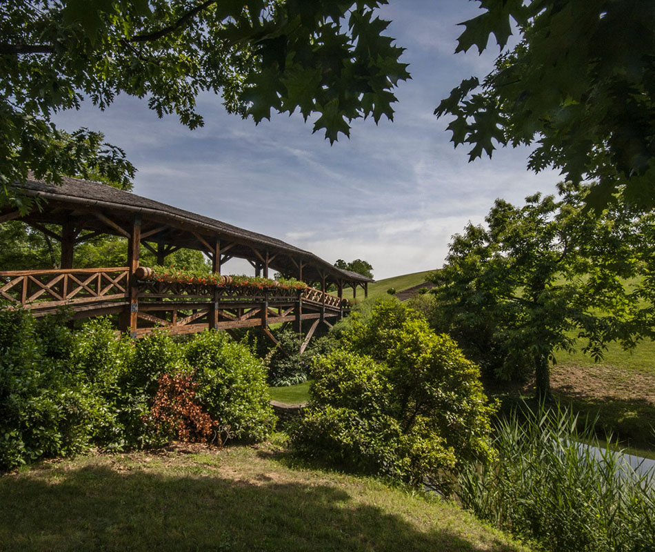 A grandiose gate, sculptor Arnaldo Pomodoro’s bronze “Hymn to the Sun”, which opens onto a sweeping park framed by oak, chestnut and acacia trees.